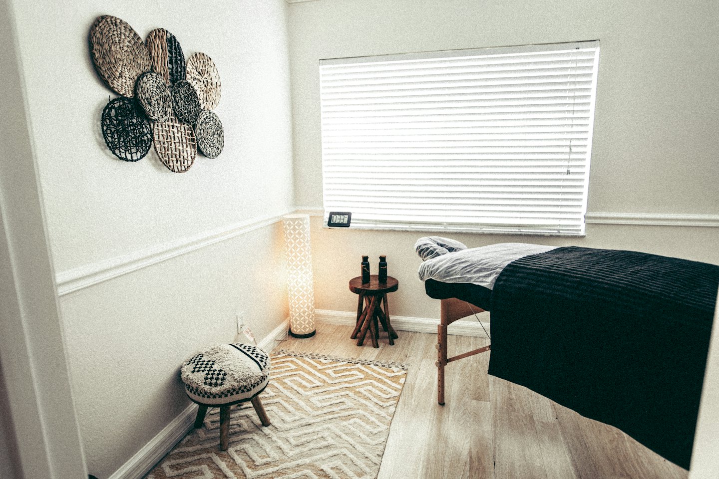Lege massagetafel in een rustige behandelruimte met houten vloer.