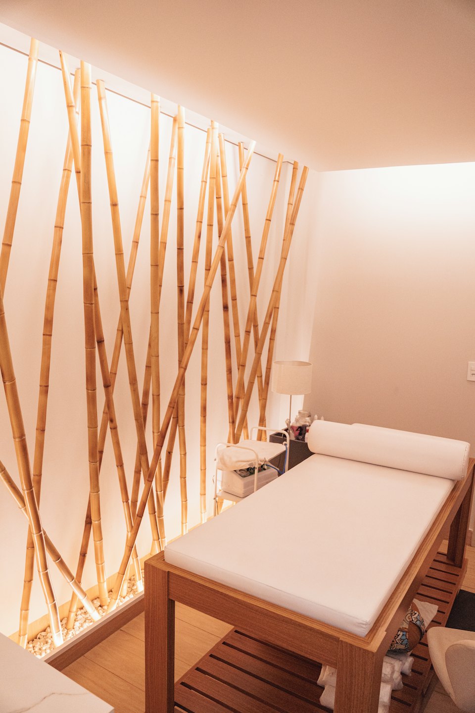 Lege spa kamer met bamboe muur en massagetafel.